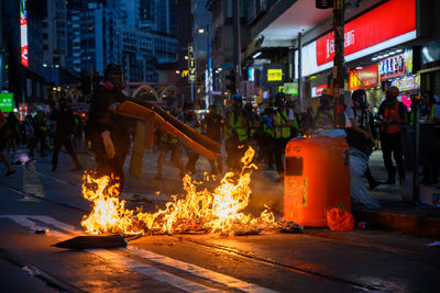 People on illuminated fire in city at night