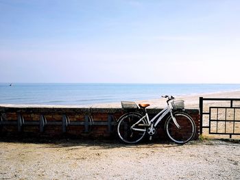Bicycles on beach against sky