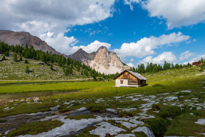 Scenic view of house and mountains against sky at sunset 