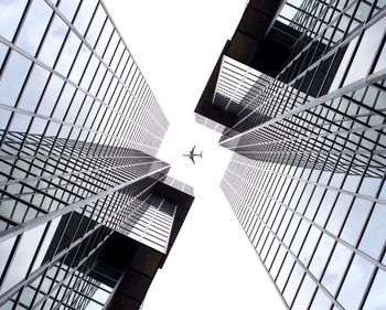 Directly below shot of airplane flying over skyscrapers