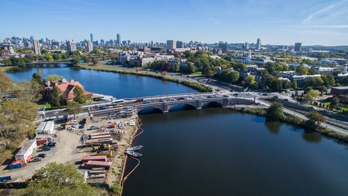 Arch bridge over river in city against sky