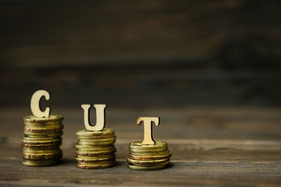 Close-up of coins with cut text on table