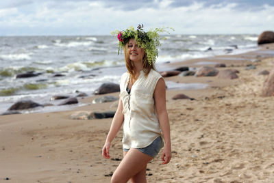 Full length of smiling young woman on beach