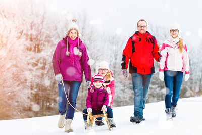 Rear view of women standing in snow