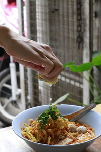 Midsection of person holding food in plate on table