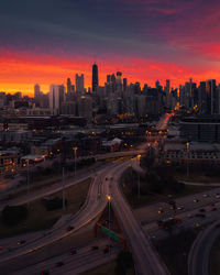 High angle view of illuminated city at sunset