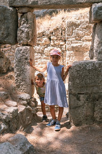 Kids sibling girl and boy travelers travel and explore the ancient excavations of the ruins