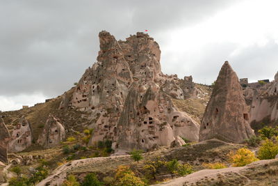 Low angle view of rock formation against cloudy sky