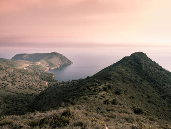 Scenic view of sea and mountains against sky during sunset