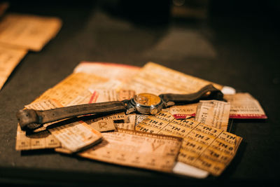 Close-up of old wristwatch with papers on table