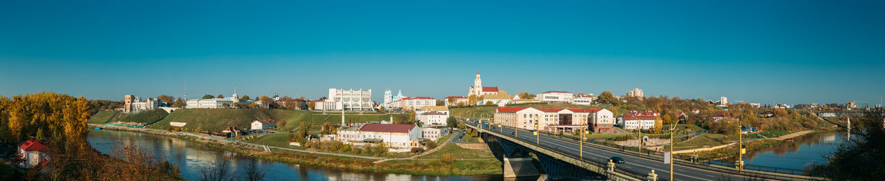 Buildings in city against clear blue sky