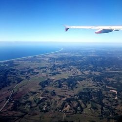 Low angle view of airplane wing over landscape