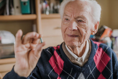 Senior man holding medicine at home