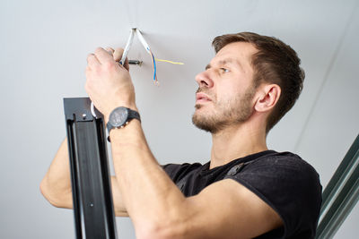 Side view of man repairing car