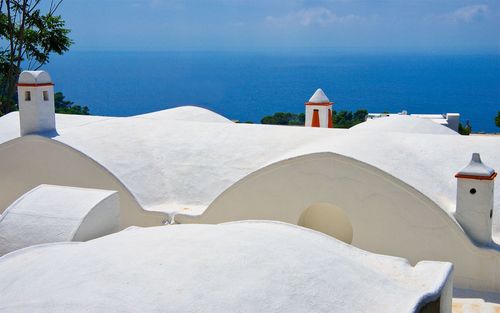 View of white building by sea against sky