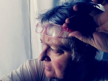 Close-up of man wearing eyeglasses at home