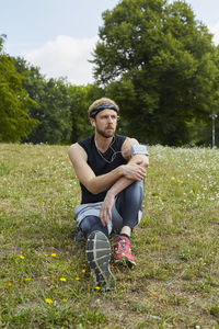 Full length of young man sitting on field