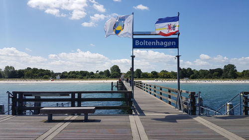 Pier on sea against cloudy sky