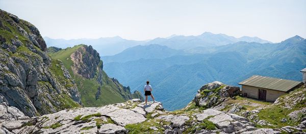 Man standing on rock against sky