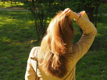 Rear view of woman standing on grassy field