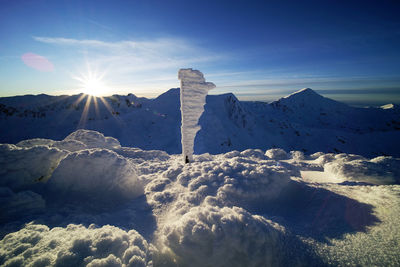 Scenic view of snow covered mountains against sky