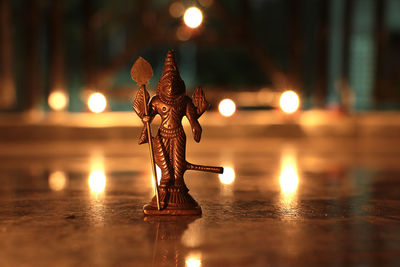 Close-up of illuminated sculpture against water