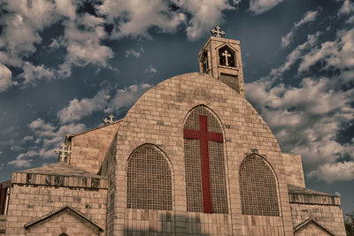 Low angle view of building against cloudy sky