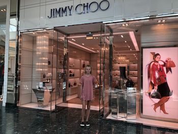 People standing on glass with reflection of building