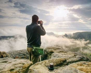 Fall nature photographer prepare camera to takes impressive photos of fall mountains. sharp edge