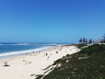 Scenic view of beach against clear blue sky