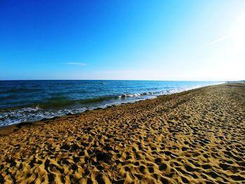 Scenic view of beach against clear blue sky