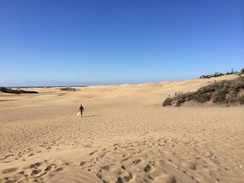 Scenic view of desert against clear blue sky