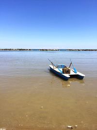 Boats in sea against clear sky