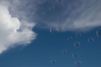 Low angle view of bubbles against sky