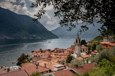 Town by sea and mountains against sky