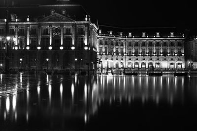 Reflection of buildings in lake at night