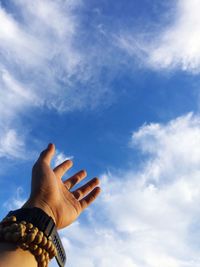 Cropped hand of person gesturing towards sky