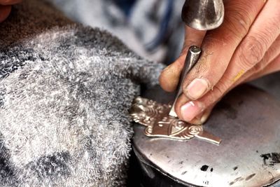 Cropped hand working on metal