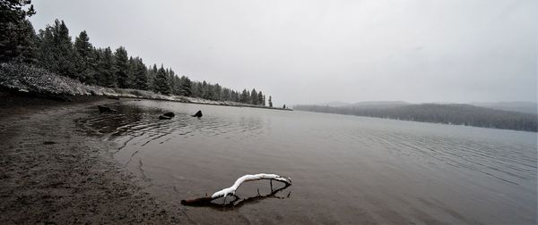 Scenic view of lake against sky during winter