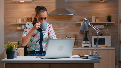 Young woman using laptop at table