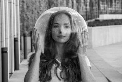 Portrait of young woman wearing glass helmet in head on sidewalk