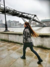 Woman with umbrella against sky in city