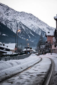 Road by snowcapped mountains against sky