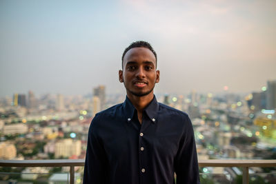 Portrait of young man standing against sky