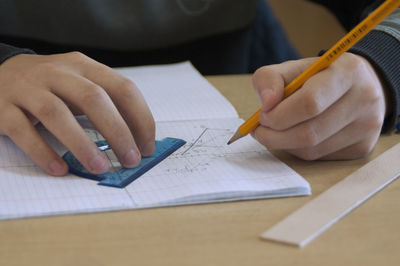 Close-up of hand holding book on table