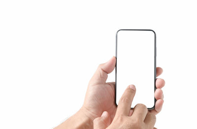 Close-up of hand holding mobile phone over white background