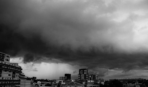 Buildings in city against cloudy sky