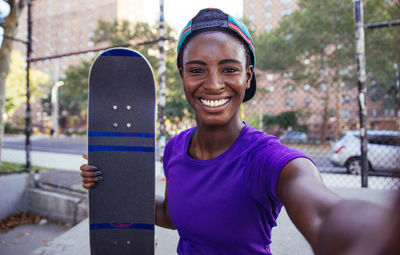 Portrait of smiling young woman standing outdoors