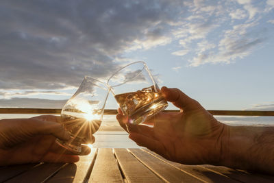 Close-up of a man drinking water at sunset