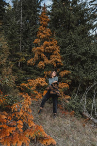 Man standing by trees in forest during autumn